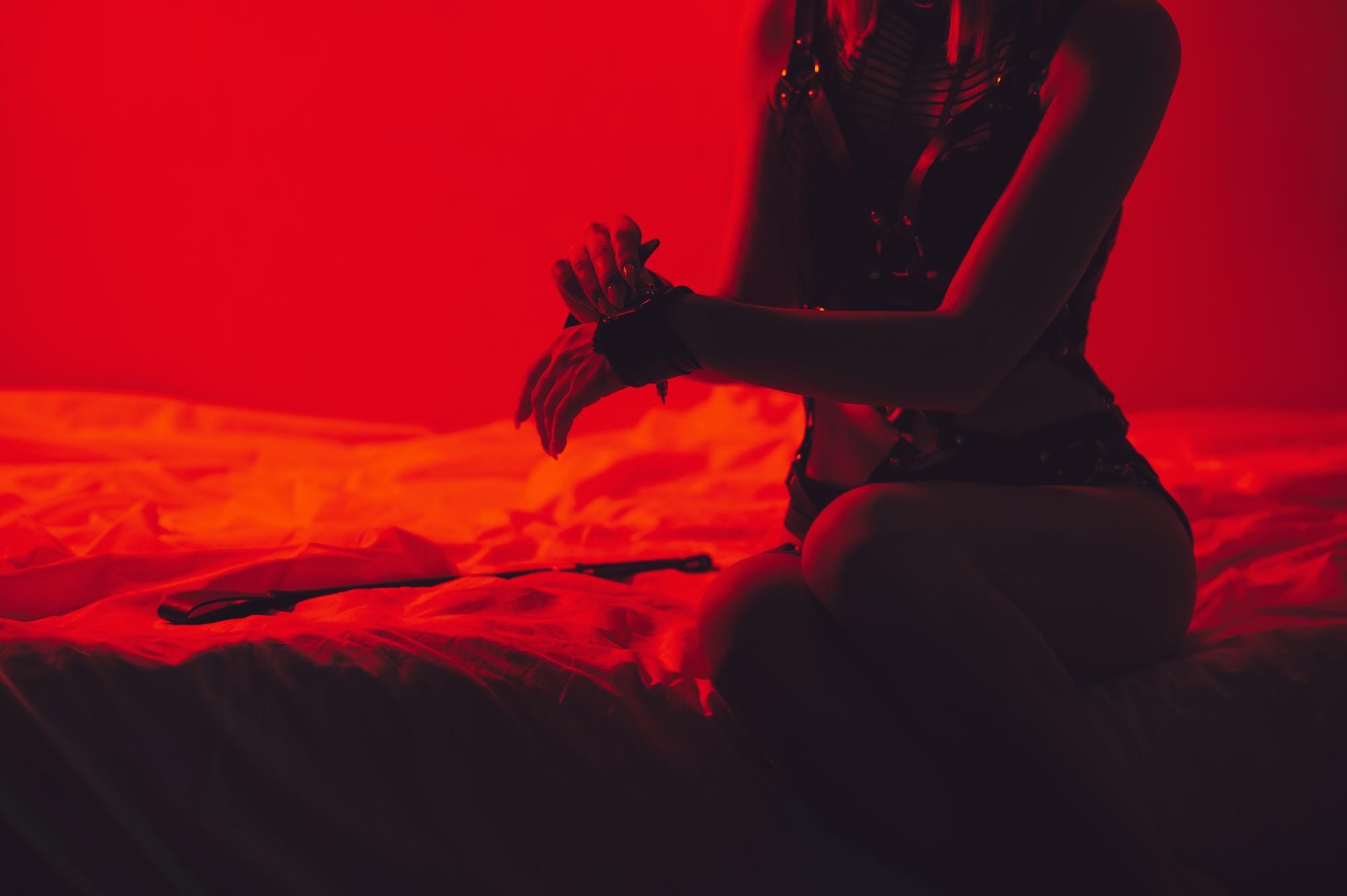 Luxurious BDSM dungeon suite with bondage furniture and moody lighting